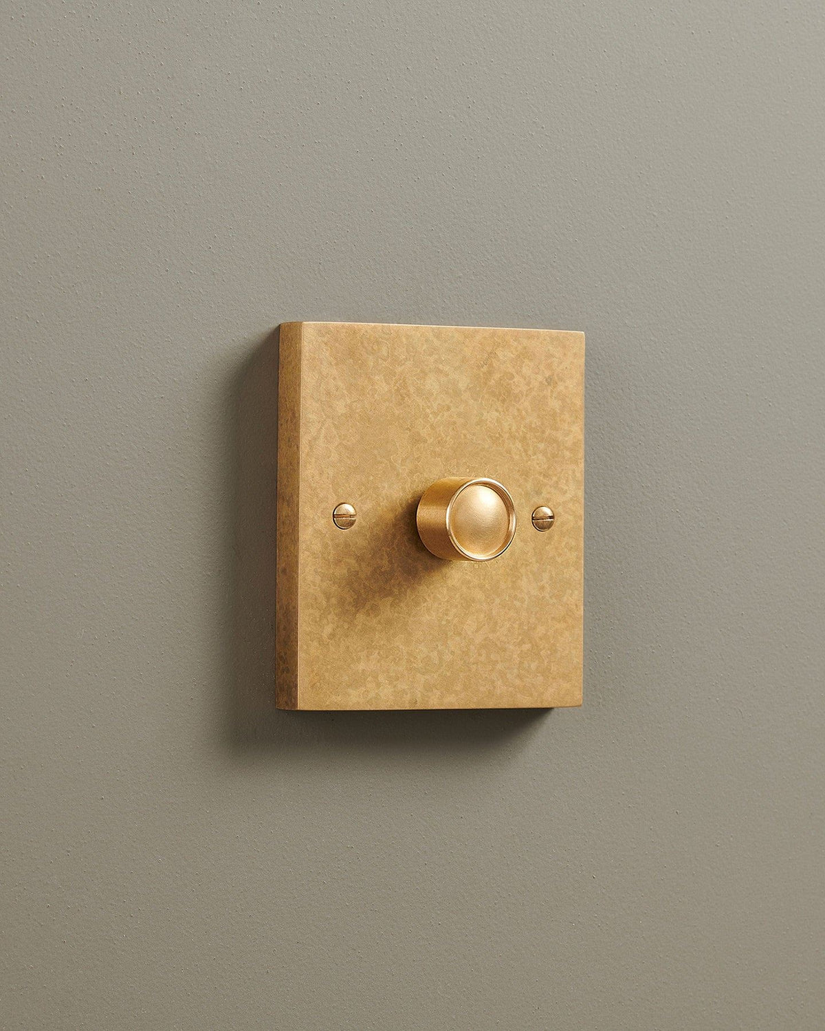 An oblique view of a 1 gang box dimmer switch in a mottled aged brass finish. TEST