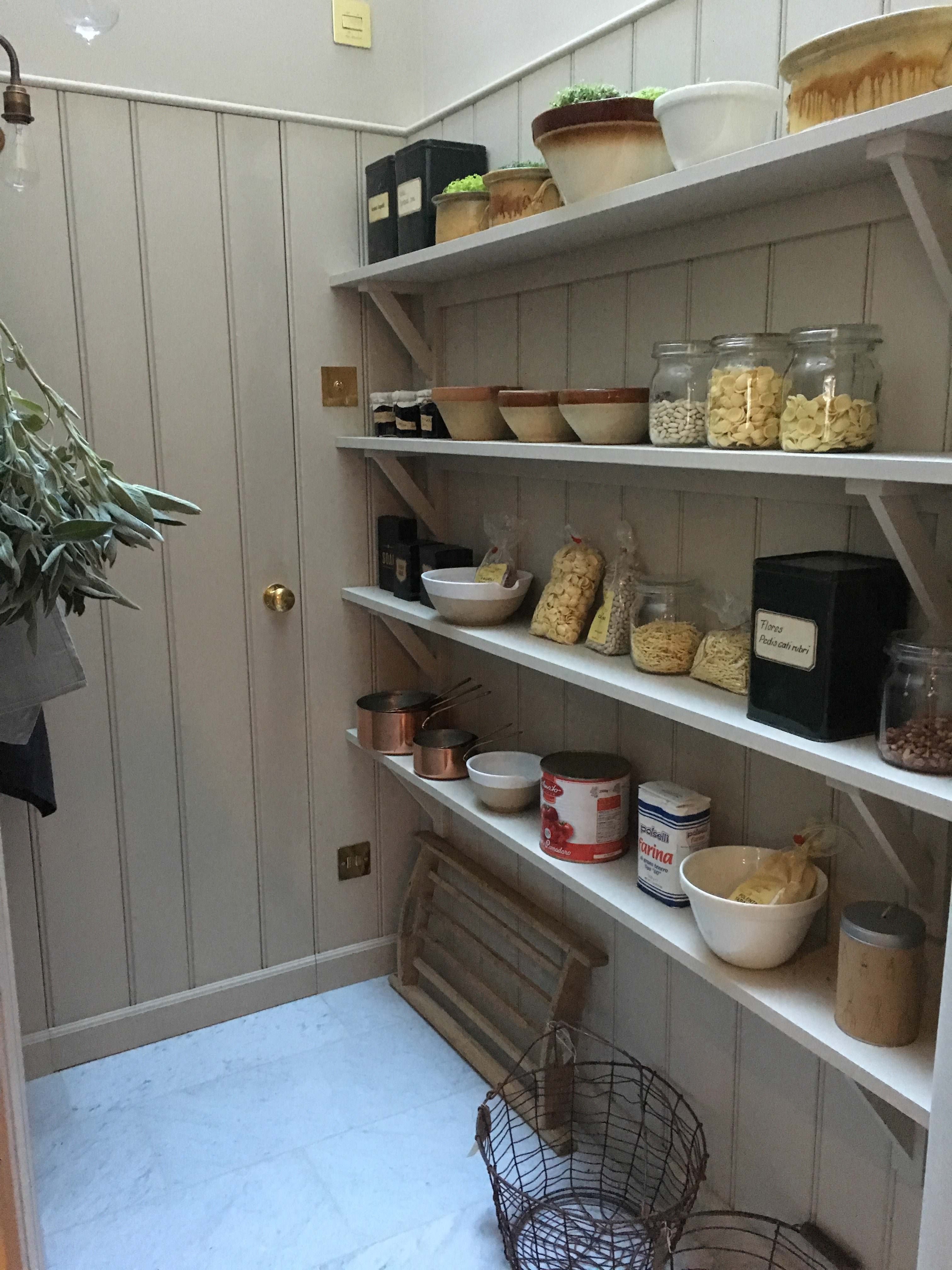 simple triangular shelves and a brass pole makes this corridor into a perfect pantry