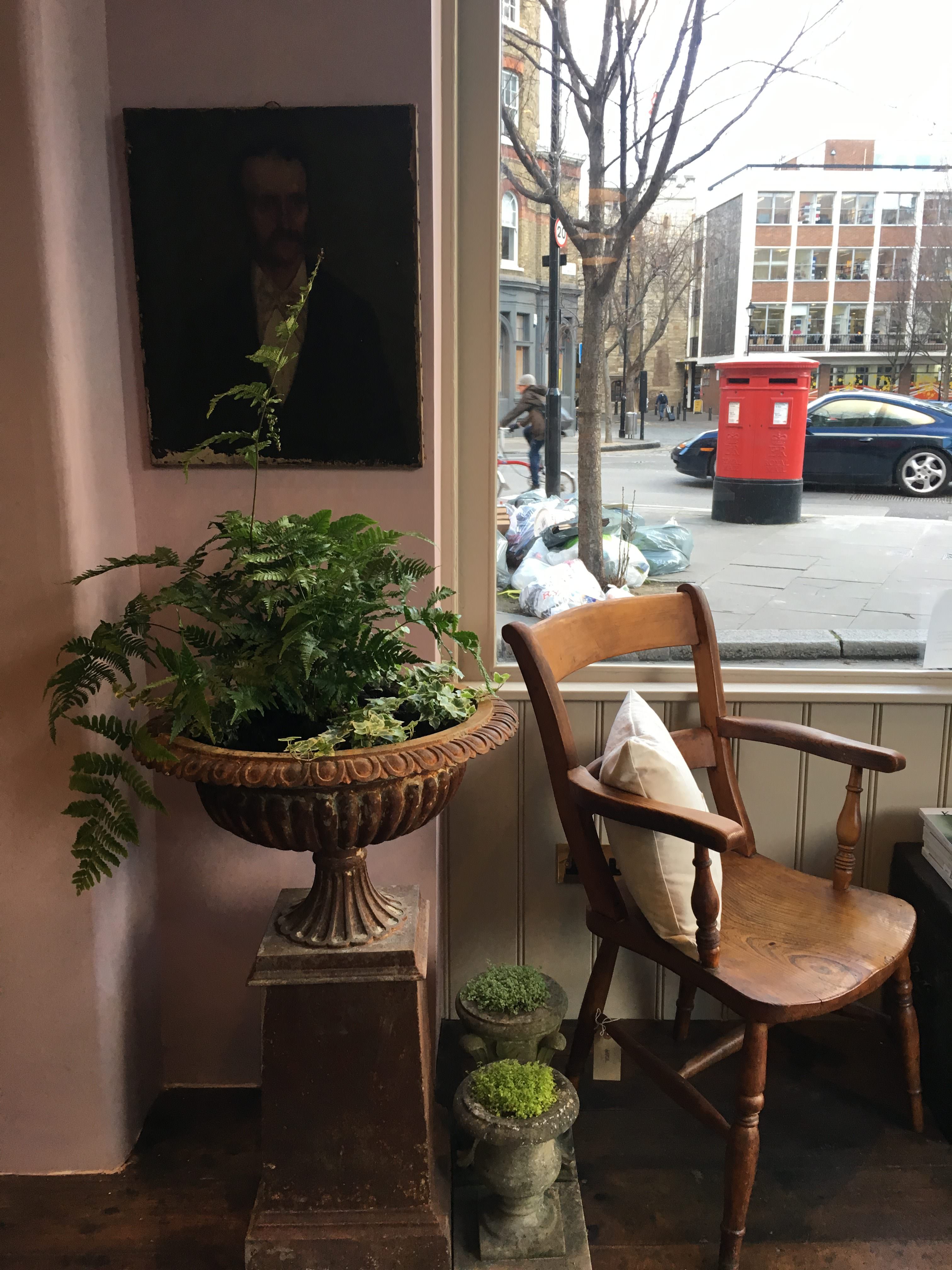 Plants and portraits and a chair with a view of The Order of St John and St Johns Gate, Clerkenwell