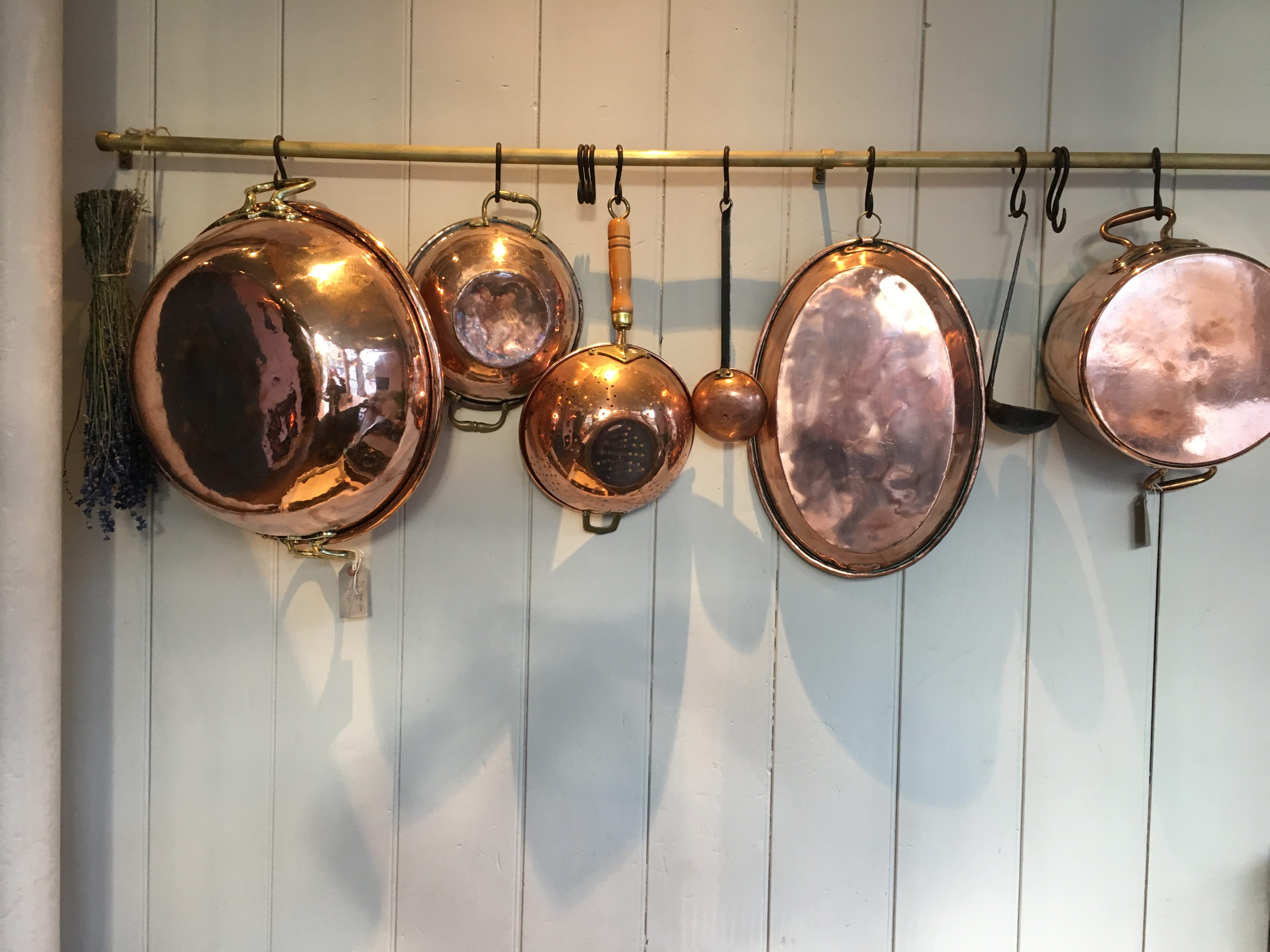 A cooks Kitchen full of copper pans and utensils