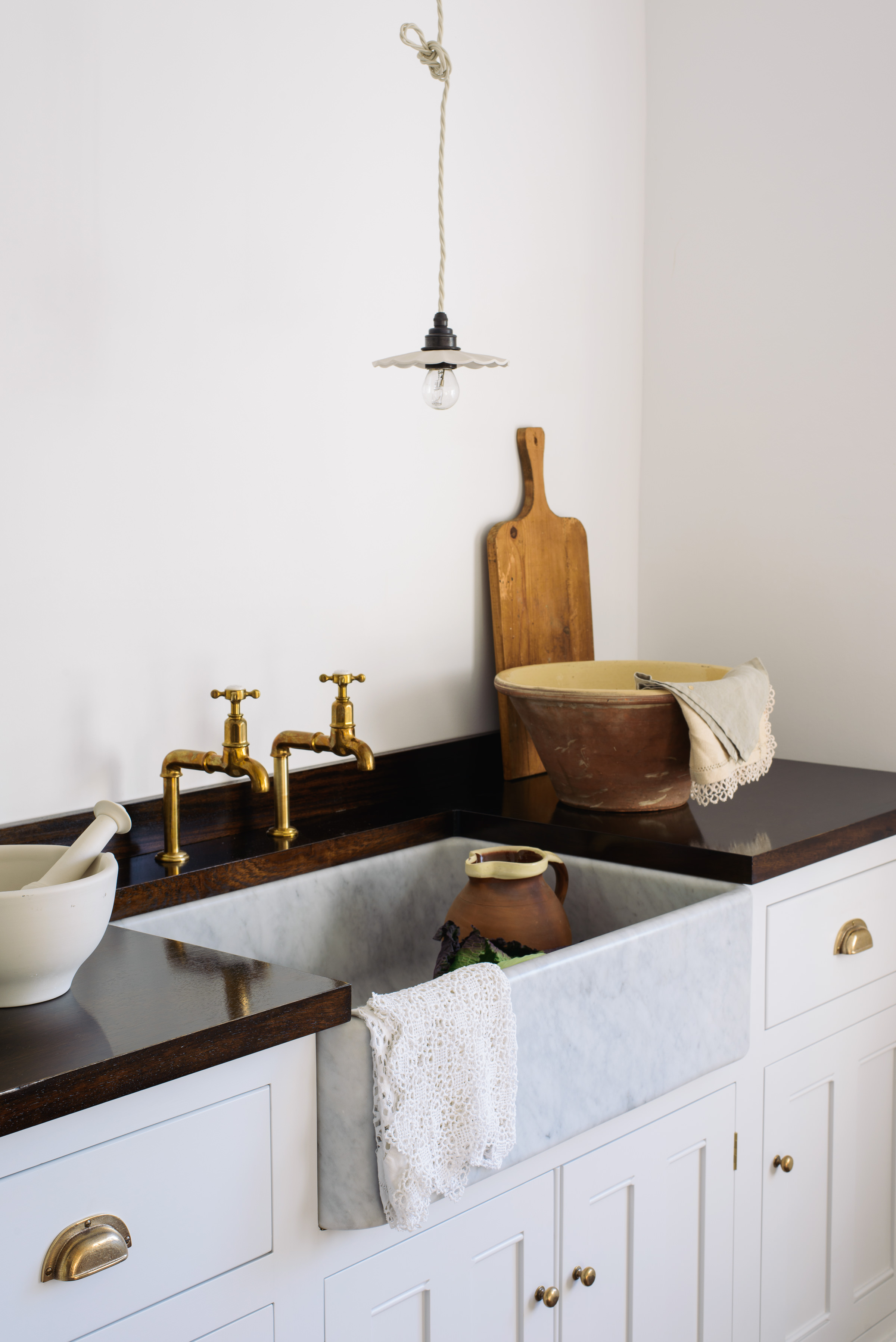 Glossy hardwood worktops work perfectly withe the marble sinks, a lovely rich contrast and a timeless look