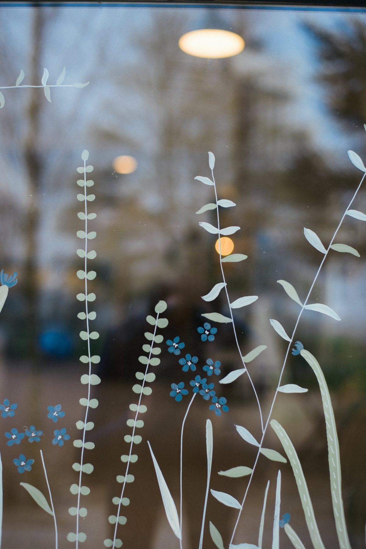 A section of the finished window. We kept it simple and natural, with trailing leaves and small blue flowers to match the blue painted building.