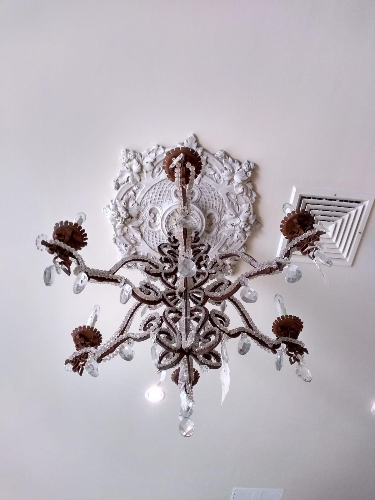 A vintage chandelier and antique ceiling rose