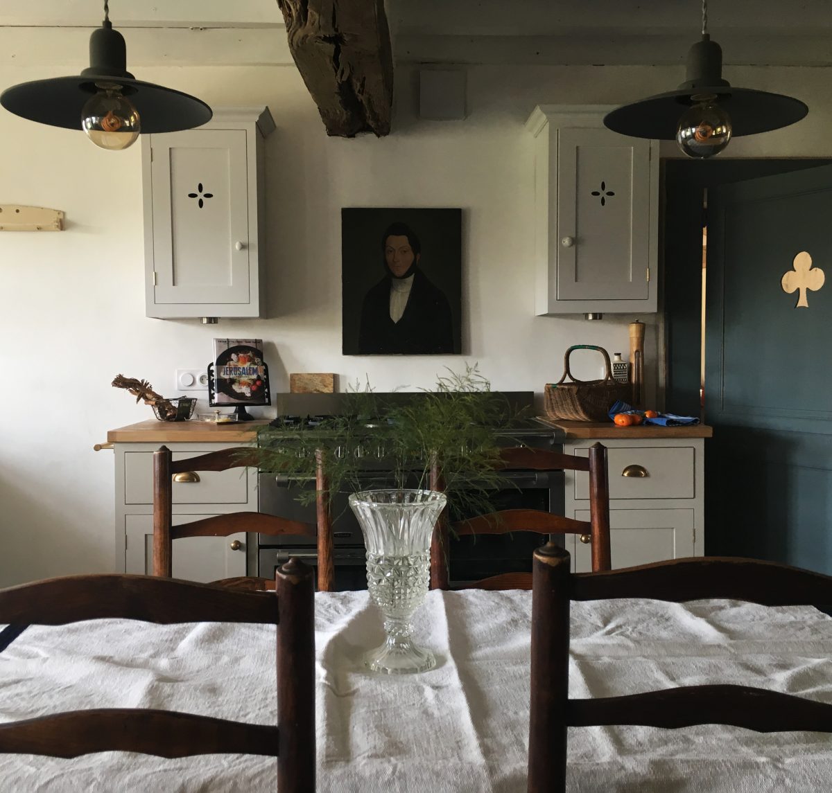 An old portrait hangs perfectly above the stainless steel range cooker. Picture perfect. 