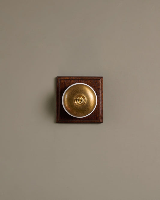 The Dolly Toggle Switch (1 Gang & Mahogany Finish Pattress) - Aged Brass with White Base.