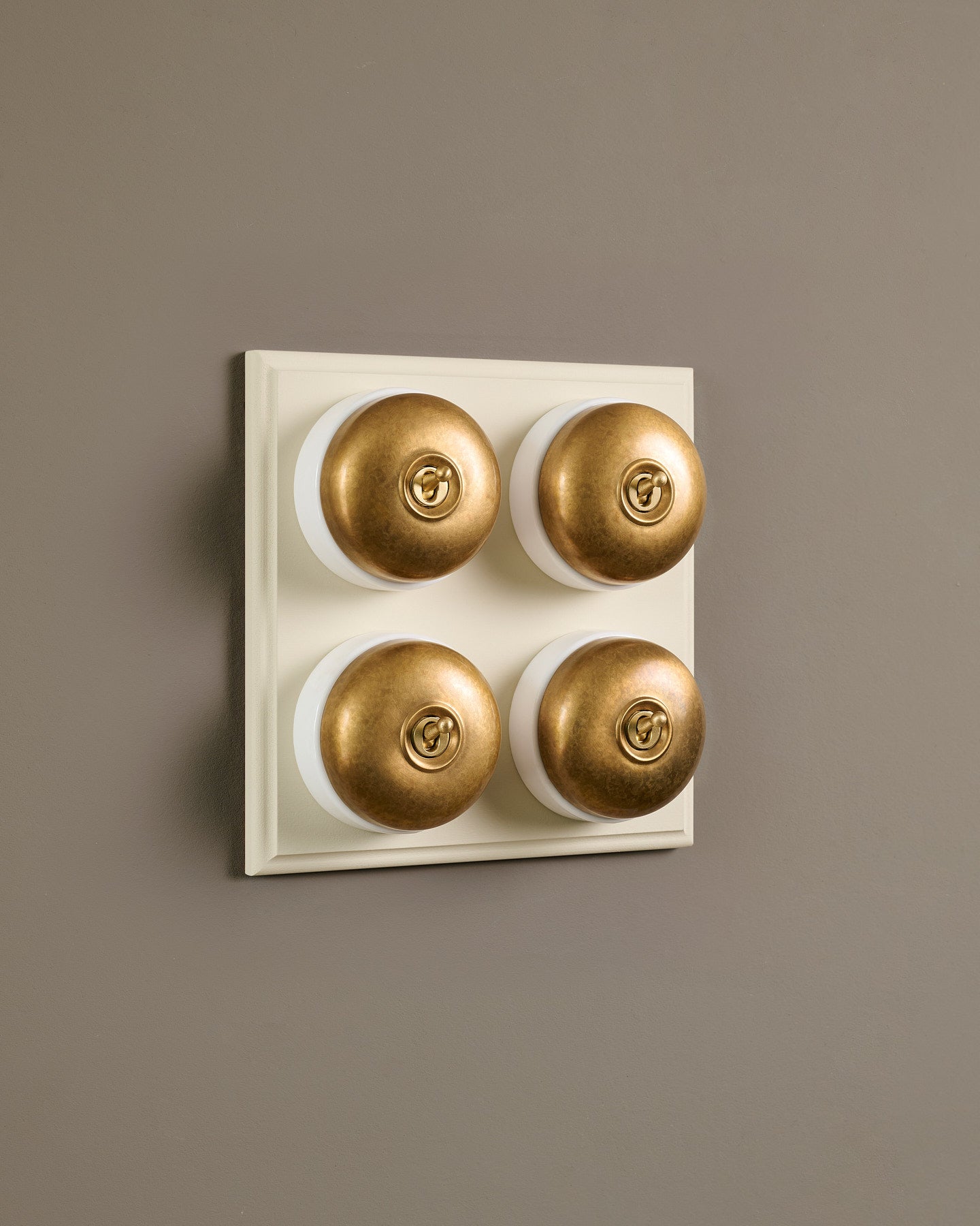 The Dolly Toggle Switch (4 Gang Bank & Primed Maple Pattress) - Aged Brass with White Base.