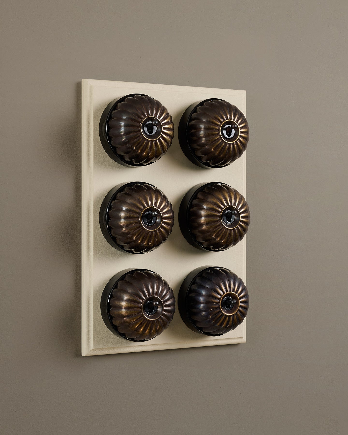 The Jelly Toggle Switch (6 Gang & Primed Maple Pattress) - Oxidised Brass with Black Base.