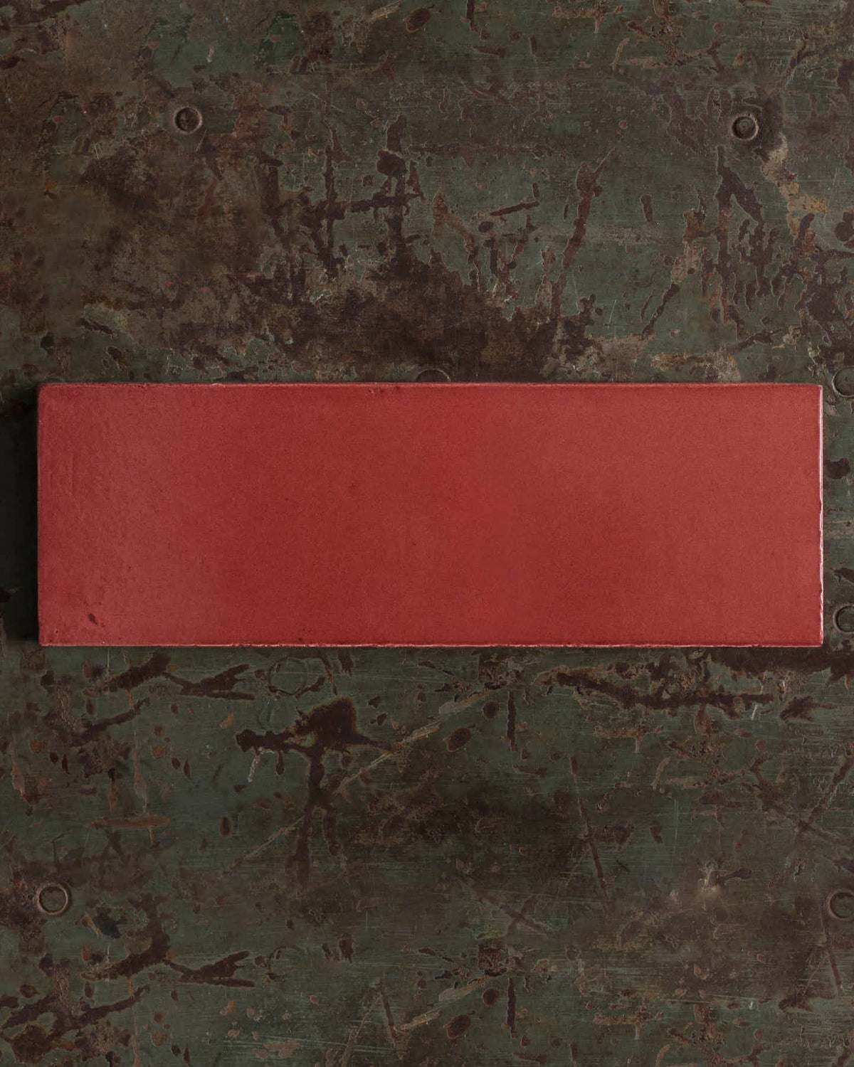Rectangular red object on a textured green surface | Plain Long Metro TEST