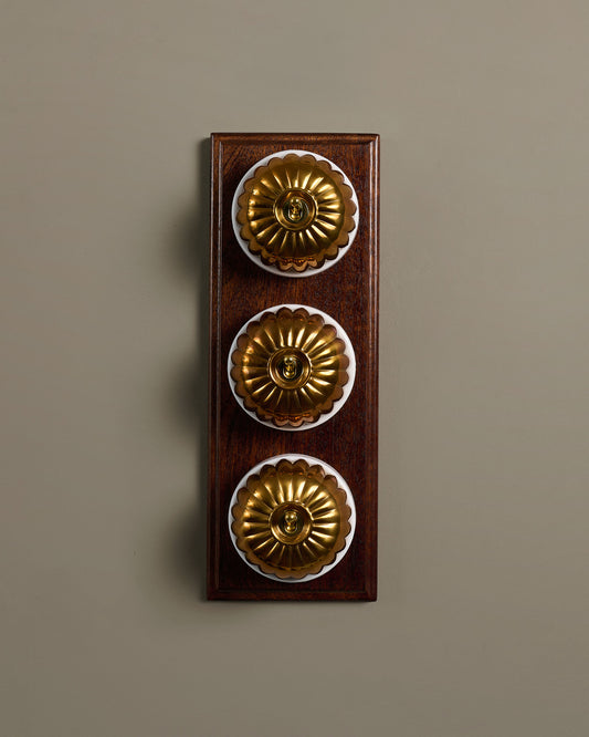 The Jelly Toggle Switch (3 Gang & Mahogany Finish Pattress) - Heirloom Brass with White Base.