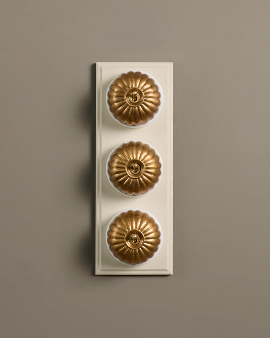 The Jelly Toggle Switch (3 Gang & Primed Maple Pattress) - Aged Brass with White Base.