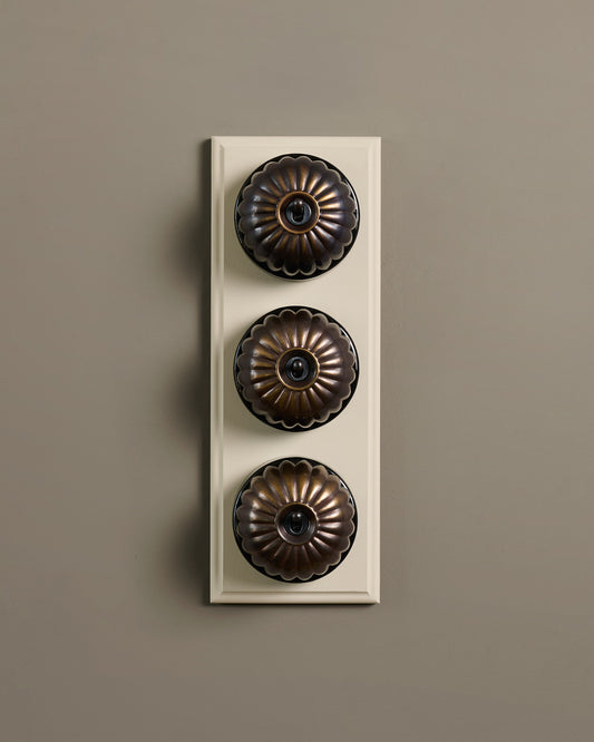 The Jelly Toggle Switch (3 Gang & Primed Maple Pattress) - Oxidised Brass with Black Base.