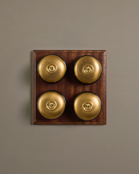 The Dolly Toggle Switch (4 Gang Bank & Mahogany Finish Pattress) - Aged Brass with Black Base.