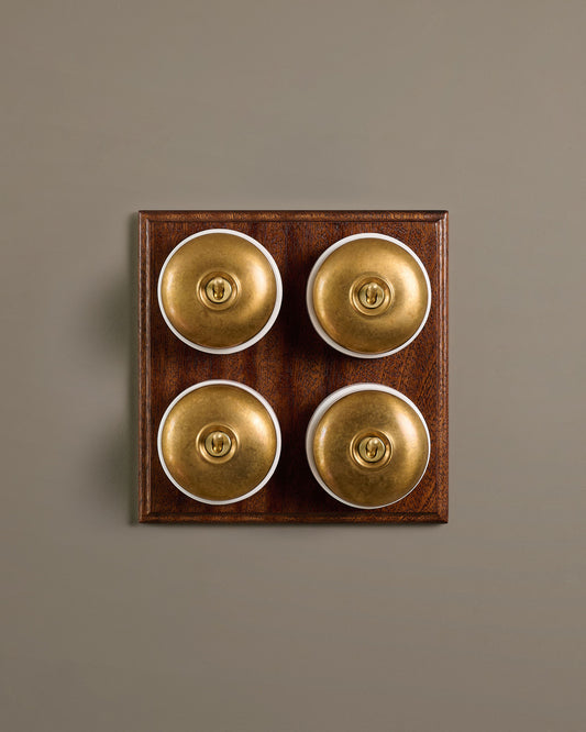 The Dolly Toggle Switch (4 Gang Bank & Mahogany Finish Pattress) - Aged Brass with White Base.