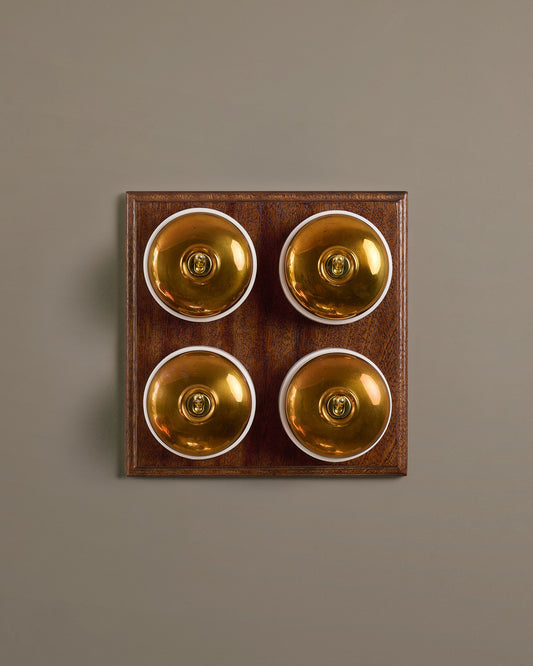The Dolly Toggle Switch (4 Gang Bank & Mahogany Finish Pattress) - Heirloom Brass with White Base.