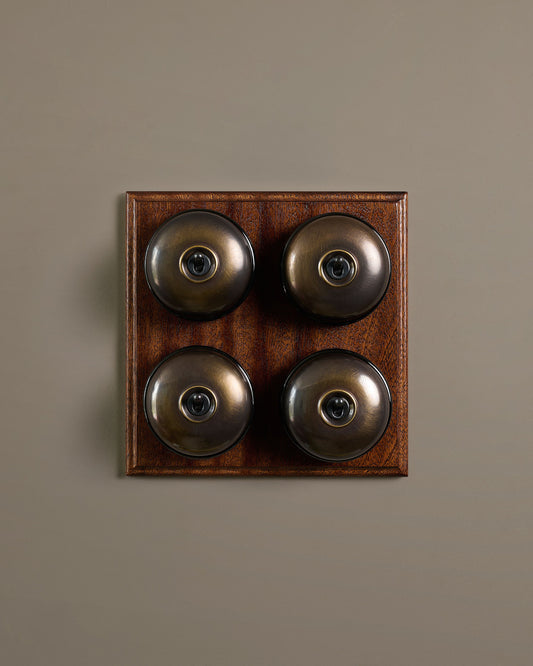 The Dolly Toggle Switch (4 Gang Bank & Mahogany Finish Pattress) - Oxidised Brass with Black Base.