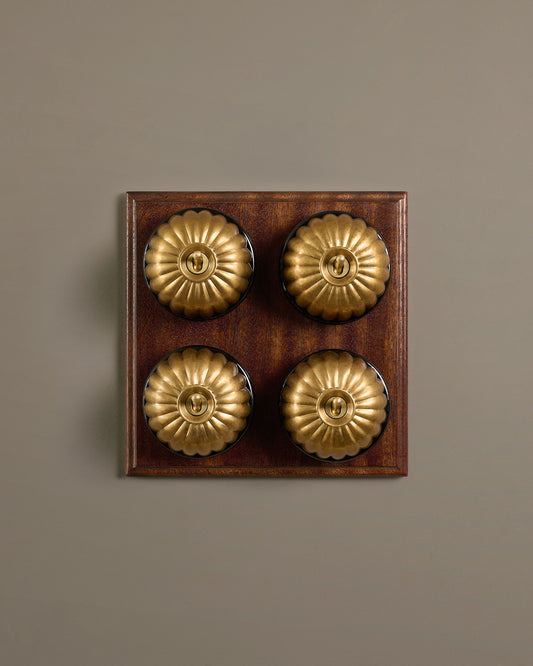 The Jelly Toggle Switch (4 Gang Bank & Mahogany Finish Pattress) - Aged Brass with Black Base.