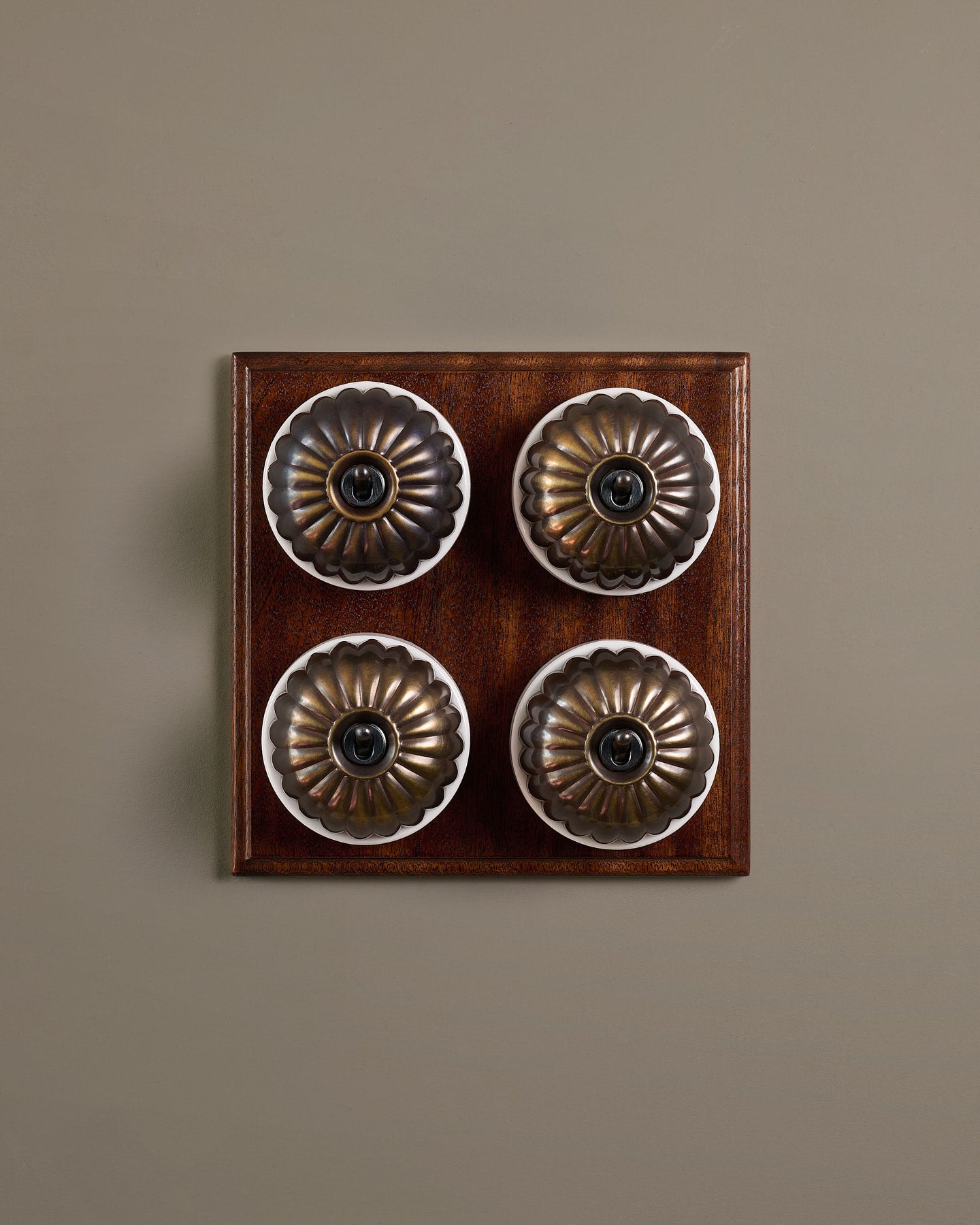 The Jelly Toggle Switch (4 Gang Bank & Mahogany Finish Pattress) - Oxidised Brass with White Base.