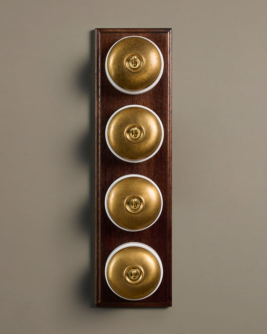 The Dolly Toggle Switch (4 Gang Row & Mahogany Finish Pattress) - Aged Brass with White Base.
