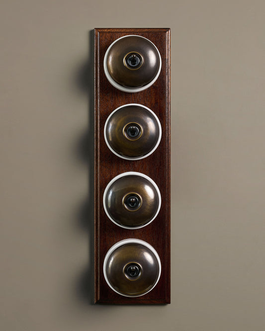 The Dolly Toggle Switch (4 Gang Row & Mahogany Finish Pattress) - Oxidised Brass with White Base.