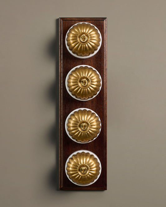 The Jelly Toggle Switch (4 Gang Row & Mahogany Finish Pattress) - Aged Brass with White Base.