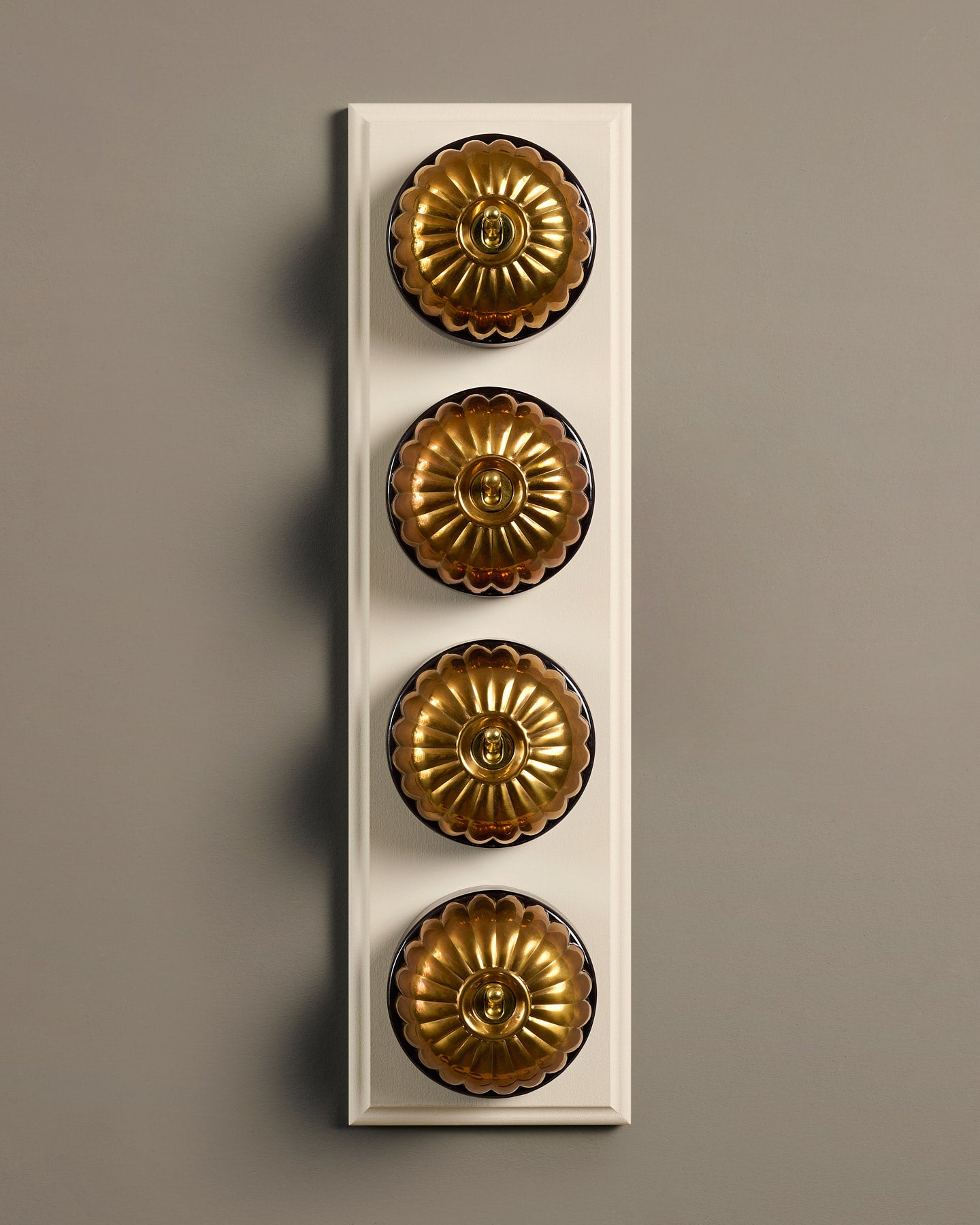 The Jelly Toggle Switch (4 Gang Row & Primed Maple Pattress) - Heirloom Brass with Black Base.