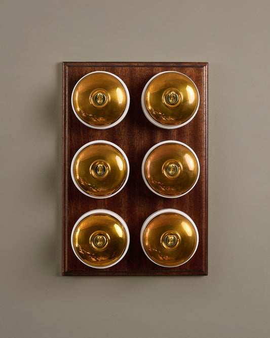 The Dolly Toggle Switch (6 Gang & Mahogany Finish Pattress) - Heirloom Brass with White Base.