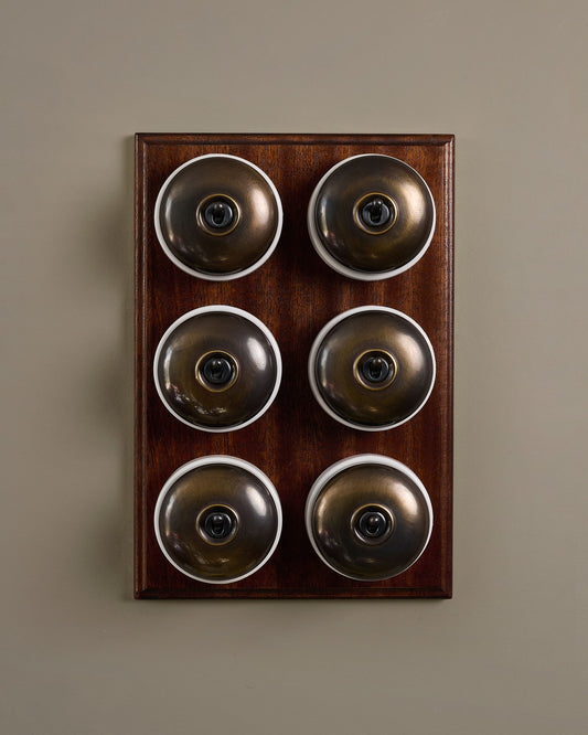 The Dolly Toggle Switch (6 Gang & Mahogany Finish Pattress) - Oxidised Brass with White Base.