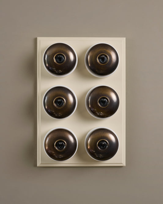 The Dolly Toggle Switch (6 Gang & Primed Maple Pattress) - Oxidised Brass with White Base.