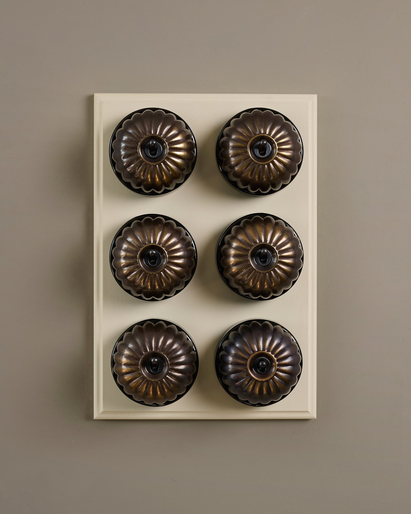 The Jelly Toggle Switch (6 Gang & Primed Maple Pattress) - Oxidised Brass with Black Base.