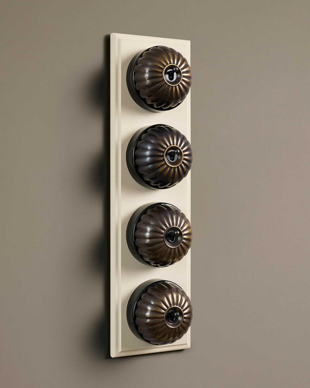 The Jelly Toggle Switch (4 Gang Row & Primed Maple Pattress) - Oxidised Brass with Black Base. TEST