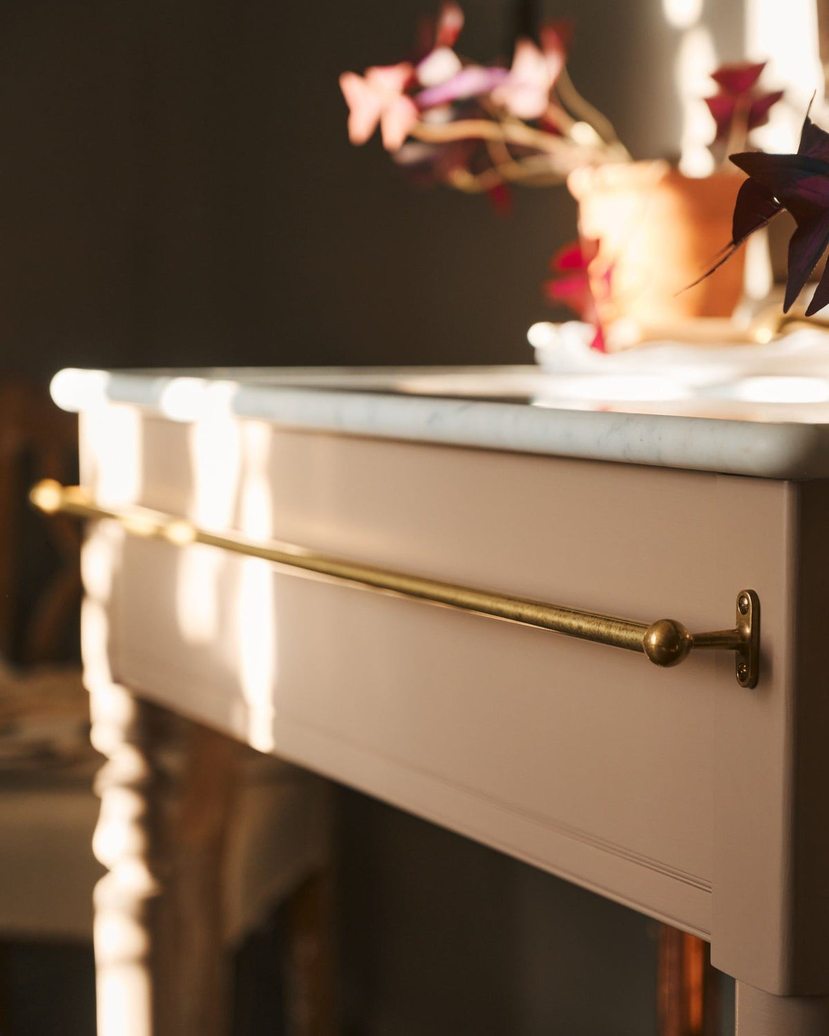 A detailed view of an aged brass towel rail attached to the front of a Victorian-inspired washstand. | Front Towel Rail shown TEST