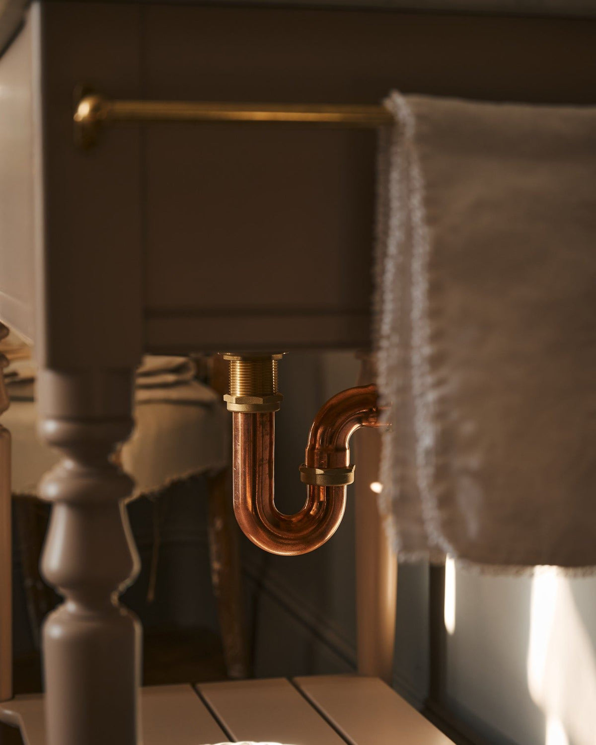 A copper p-trap fitted to a Victorian-inspired washstand. TEST