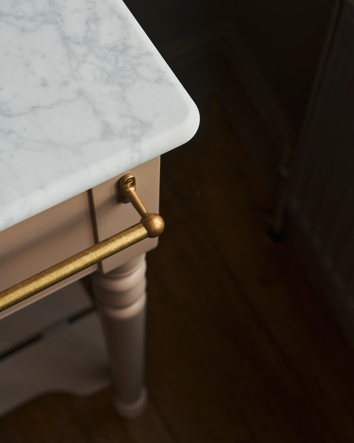 A detailed view of an aged brass towel rail attached to the front of a Victorian-inspired washstand. | Front Towel Rail shown TEST