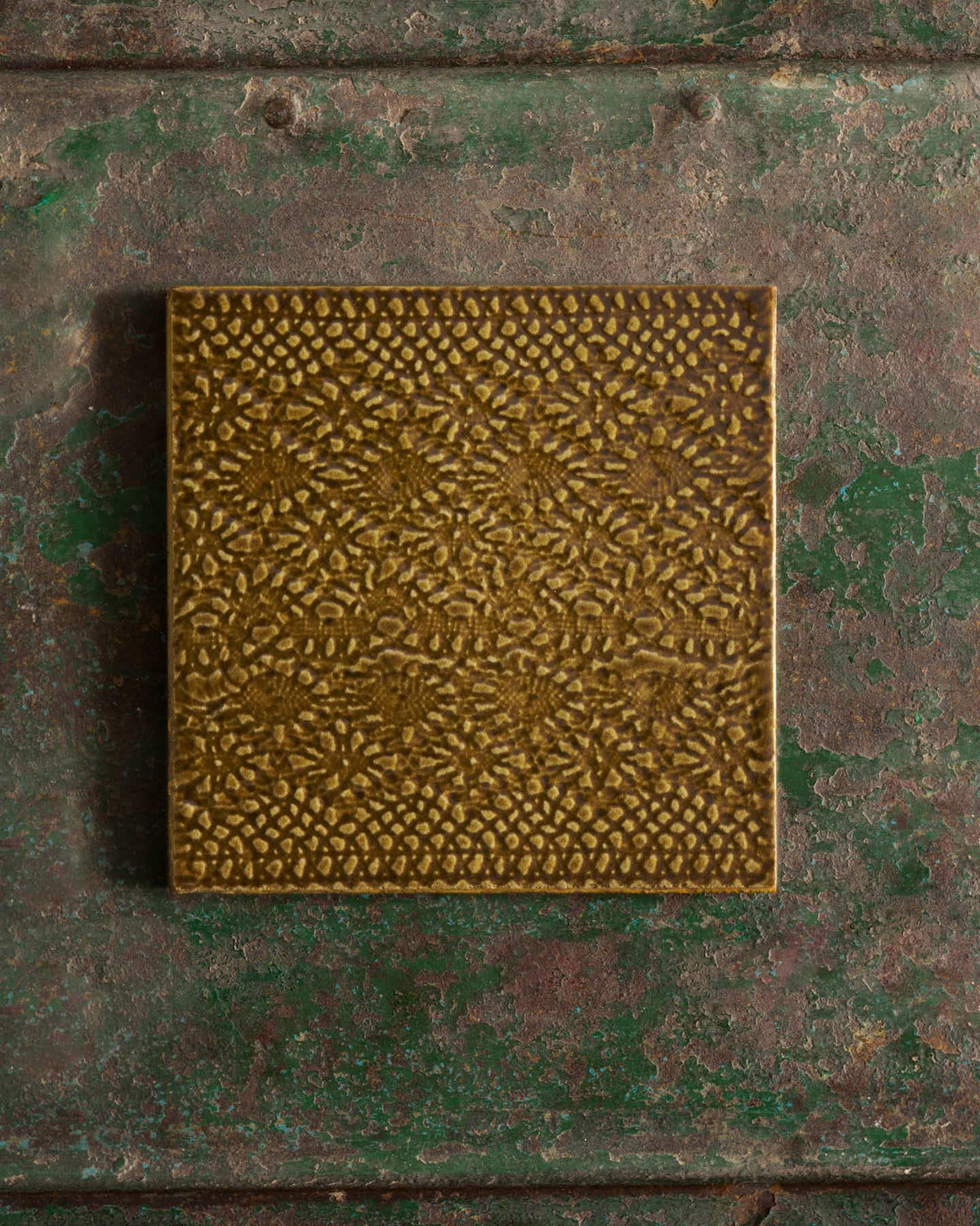 Sepia square with intricate pattern on a textured green surface | Venetian Square TEST