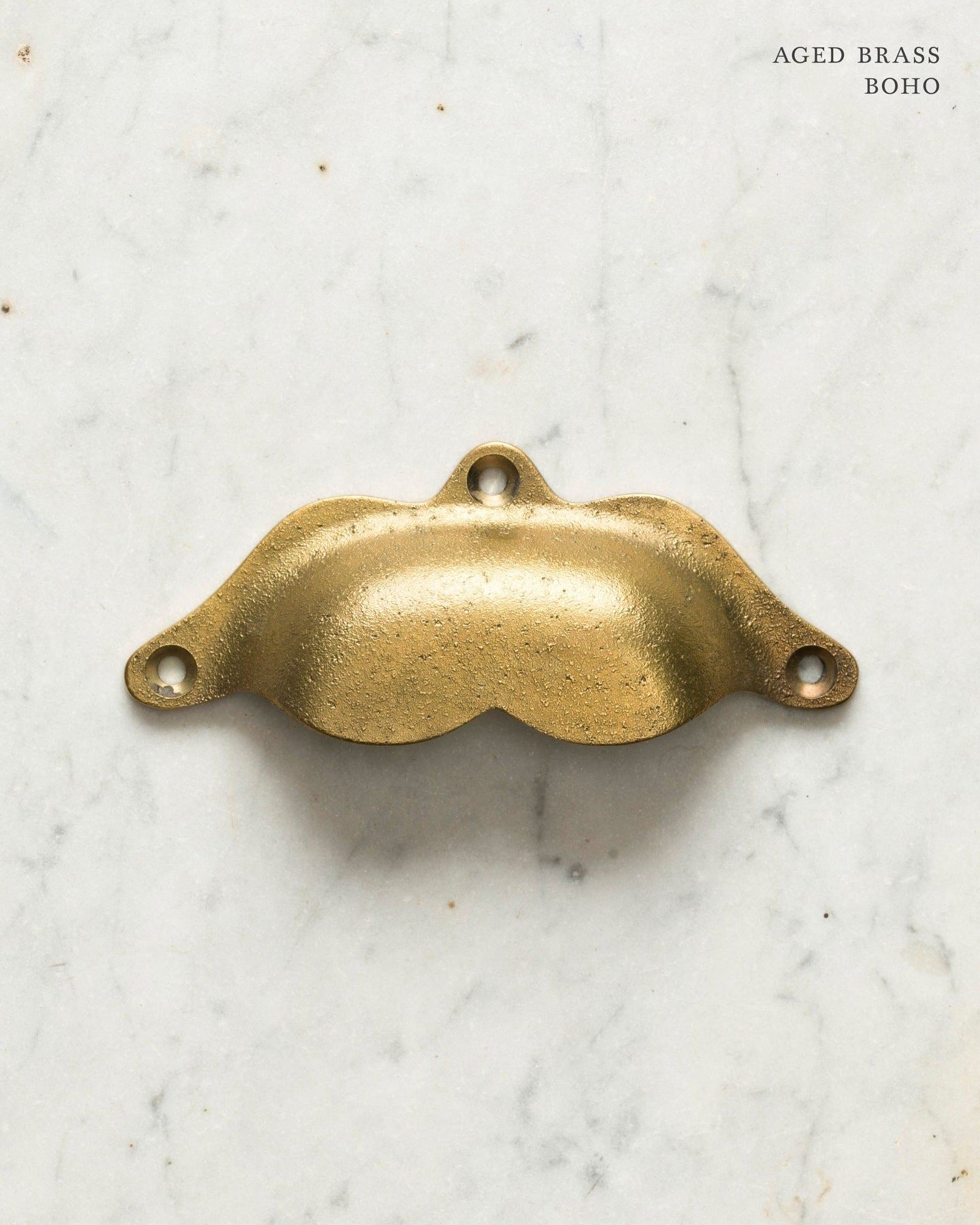Two bohemian-style cup handles for a kitchen cupboard or drawer with an aged brass finish. There is a large and a small size.
