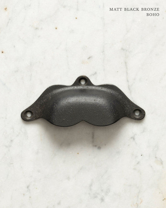 Two bohemian-style cup handles for a kitchen cupboard or drawer with a matt black bronze finish. There is a large and a small size.