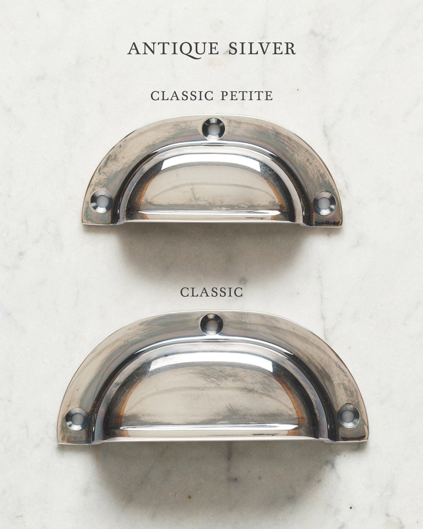 Two classic cup handles for a kitchen cupboard or drawer with a tarnished silver finish. There is a large and a small size.