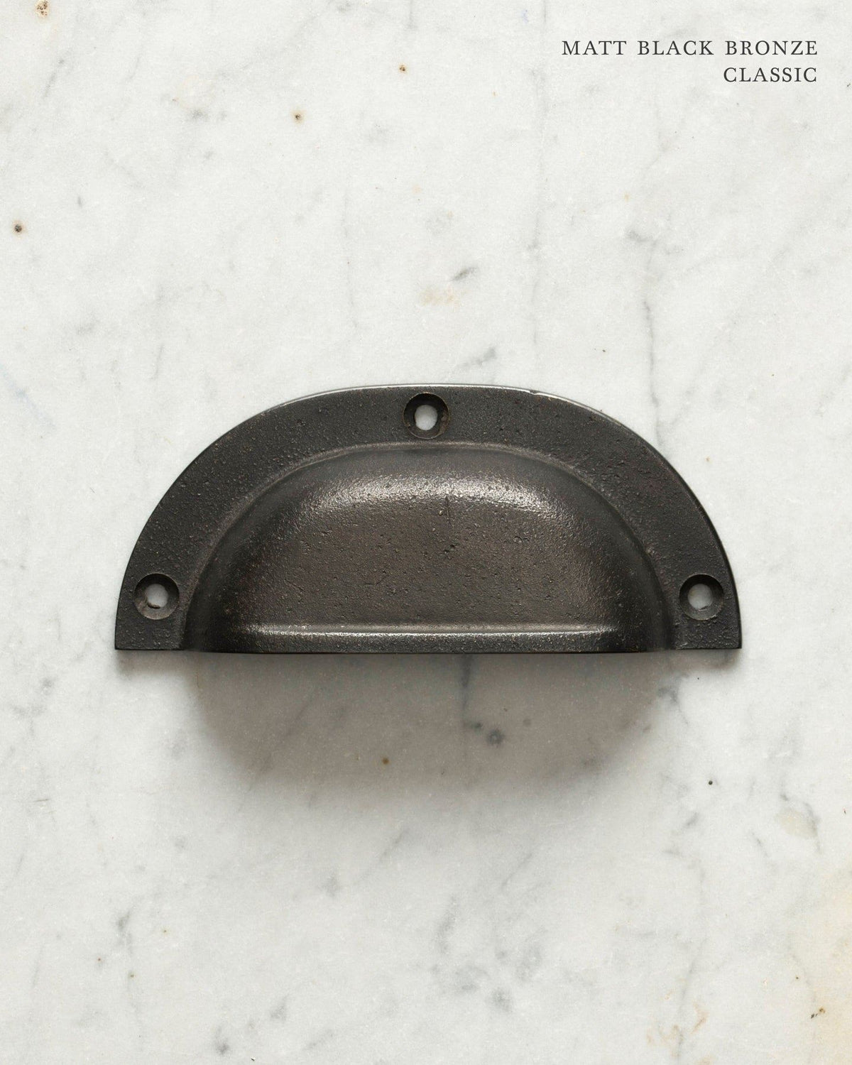 Two classic cup handles for a kitchen cupboard or drawer with a matt black bronze finish. There is a large and a small size. TEST