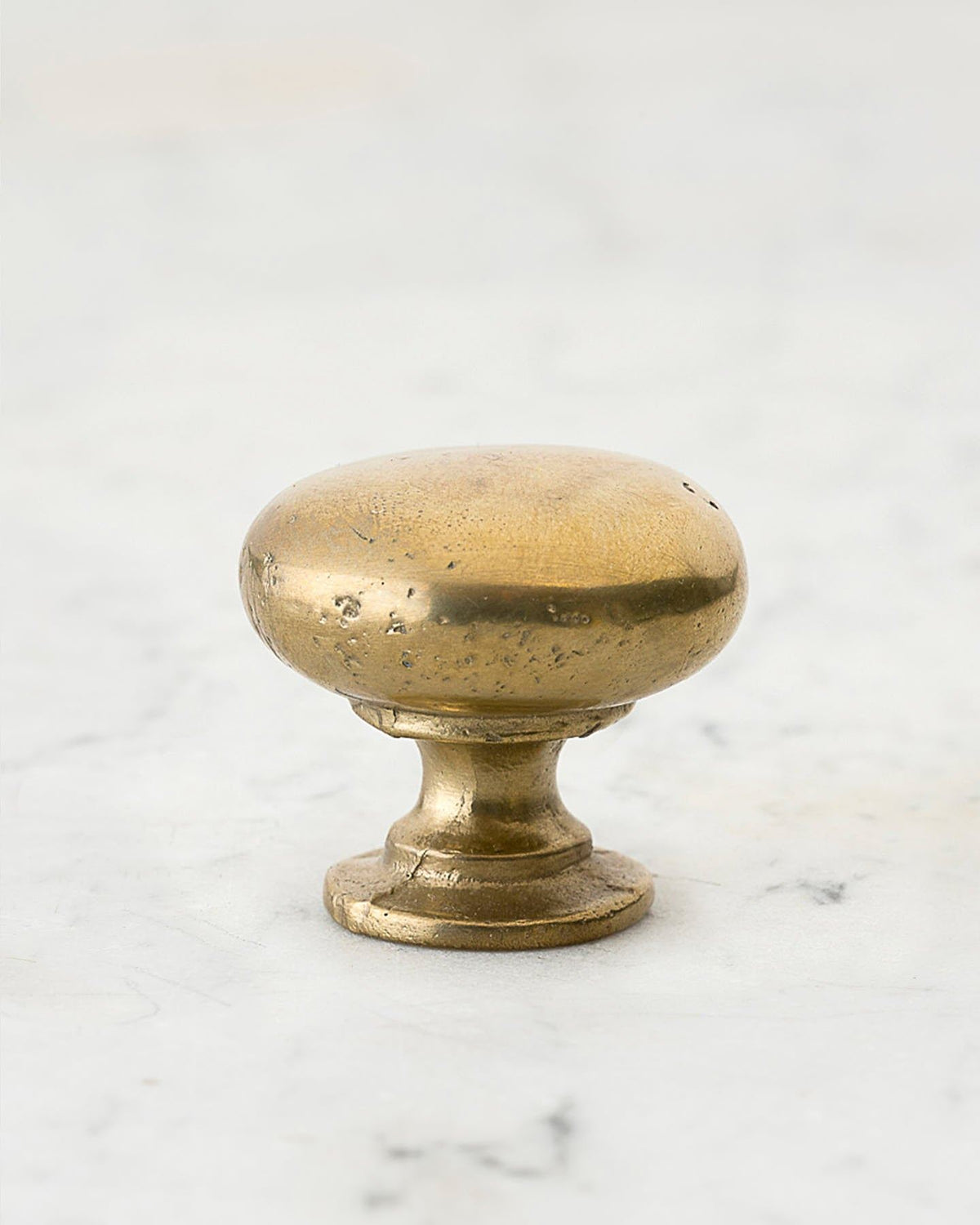 A 'Large' classic knob for a kitchen cupboard or drawer with an aged brass finish and unique dented textures that makes it look like a beloved, well aged brass from centuries ago. TEST