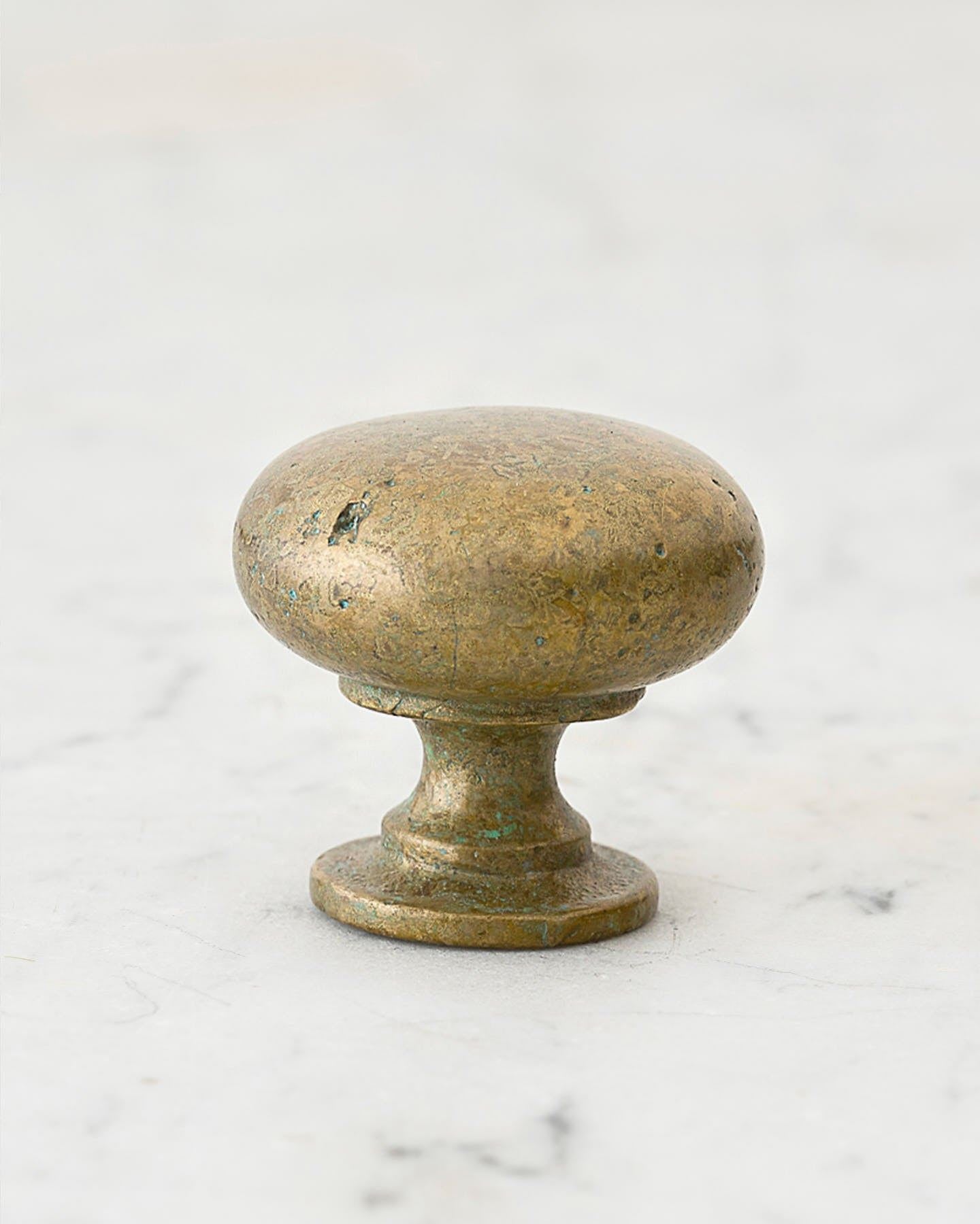 A 'Large' classic knob for a kitchen cupboard or drawer with an aged verdigris brass finish and unique dented textures as if was made by an artisan blacksmith centuries ago.