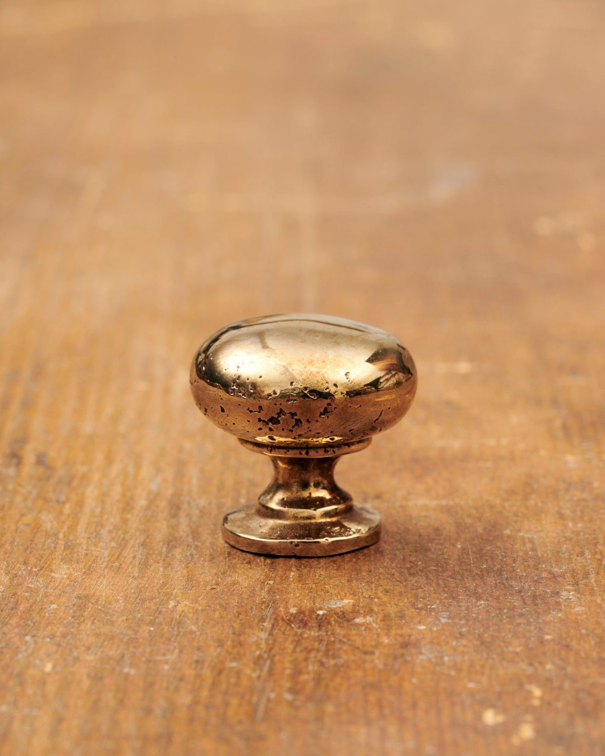 A 'Small' classic knob for a kitchen cupboard or drawer with a warm burnished brass finish and unique dented textures as if was made by an artisan blacksmith centuries ago. TEST