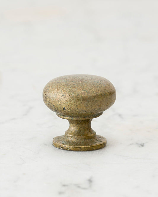 A 'Medium' classic knob for a kitchen cupboard or drawer with an aged verdigris brass finish and unique dented textures as if was made by an artisan blacksmith centuries ago.