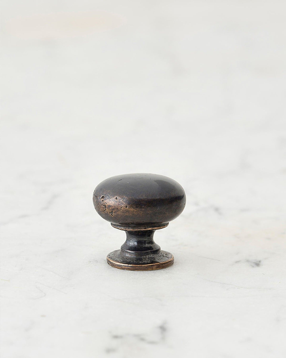 A 'Petite' classic knob for a kitchen cupboard or drawer with a dark oxidised bronze finish and unique dented textures as if was made by an artisan blacksmith centuries ago. TEST