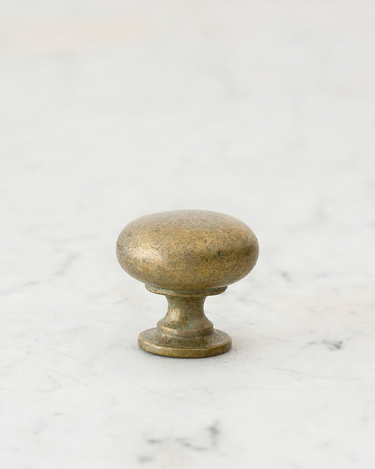 A 'Small' classic knob for a kitchen cupboard or drawer with an aged verdigris brass finish and unique dented textures as if was made by an artisan blacksmith centuries ago. TEST