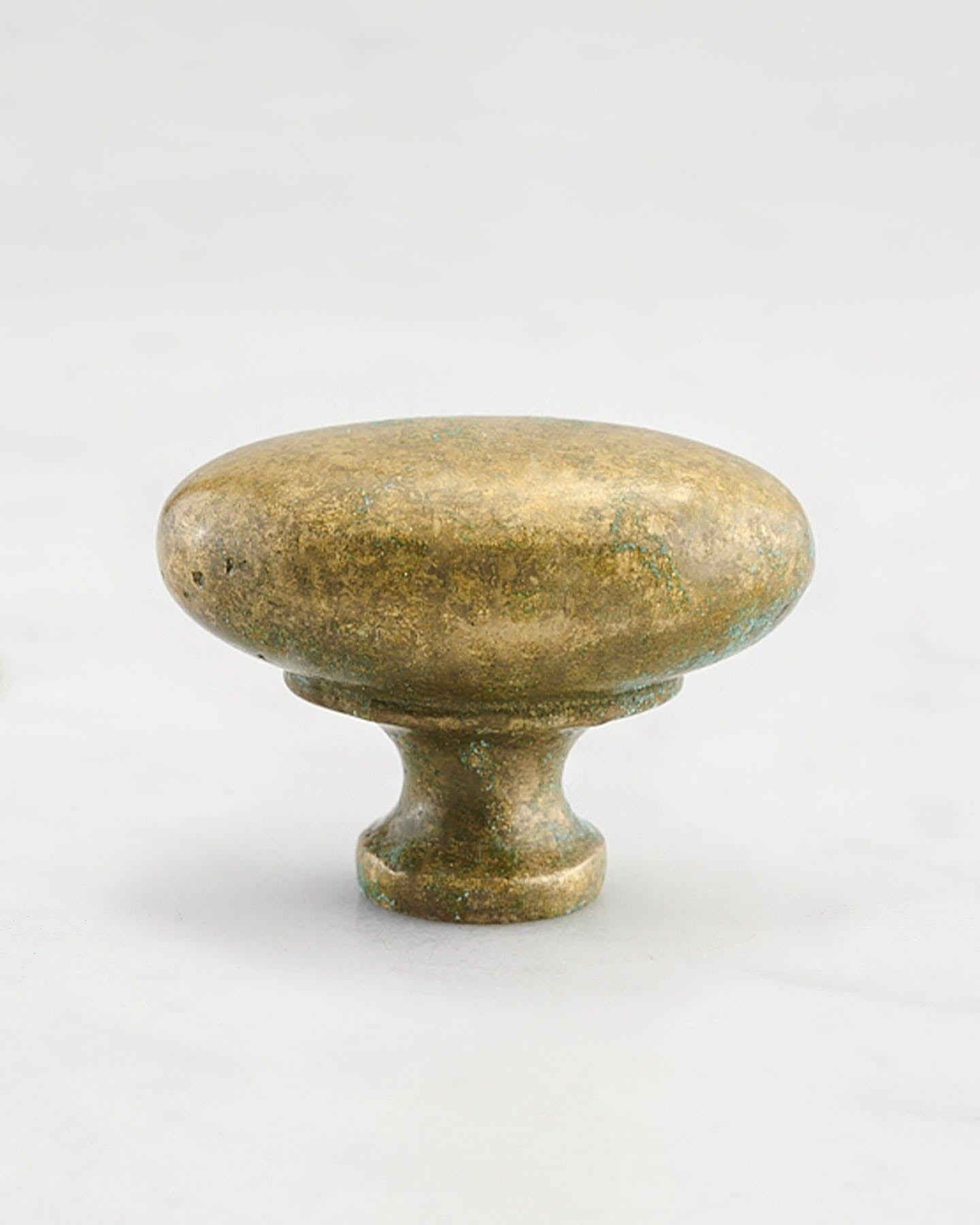 A 'Large' oval-shaped knob for a kitchen cupboard or drawer with an aged verdigris brass finish and unique dented textures as if was made by an artisan blacksmith centuries ago.