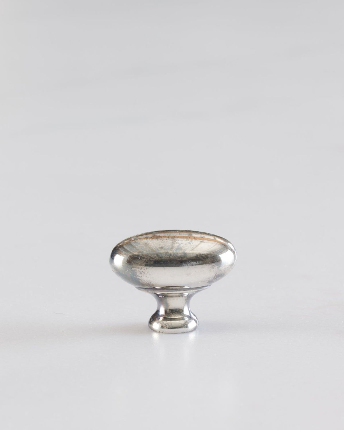 A 'Petite' oval-shaped knob for a kitchen cupboard or drawer with a tarnished silver finish. TEST