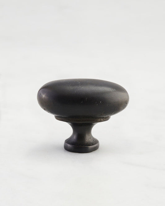 A 'Medium' oval-shaped knob for a kitchen cupboard or drawer with a matt black bronze finish that makes it look like a beloved, well aged brass from centuries ago.