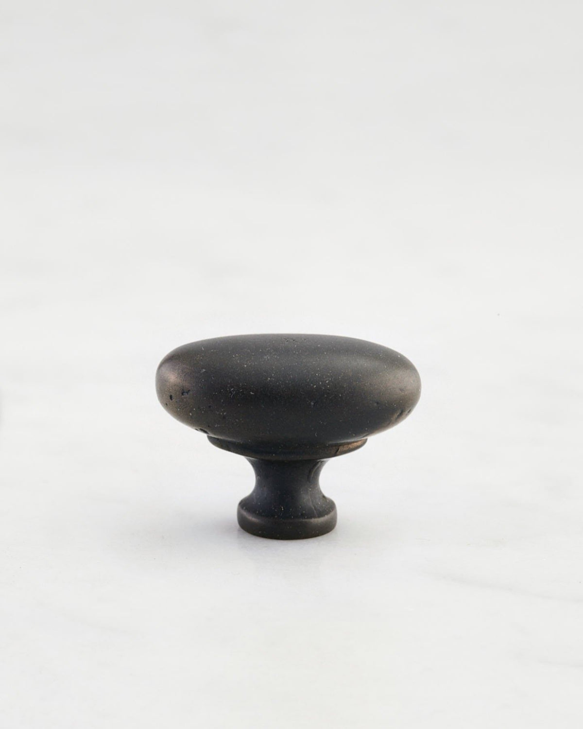 A 'Small' oval-shaped knob for a kitchen cupboard or drawer with a matt black bronze finish that makes it look like a beloved, well aged brass from centuries ago. TEST