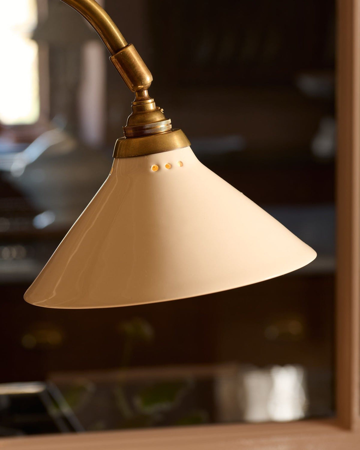 A close-up view of a small cream glazed ceramic light shade. TEST