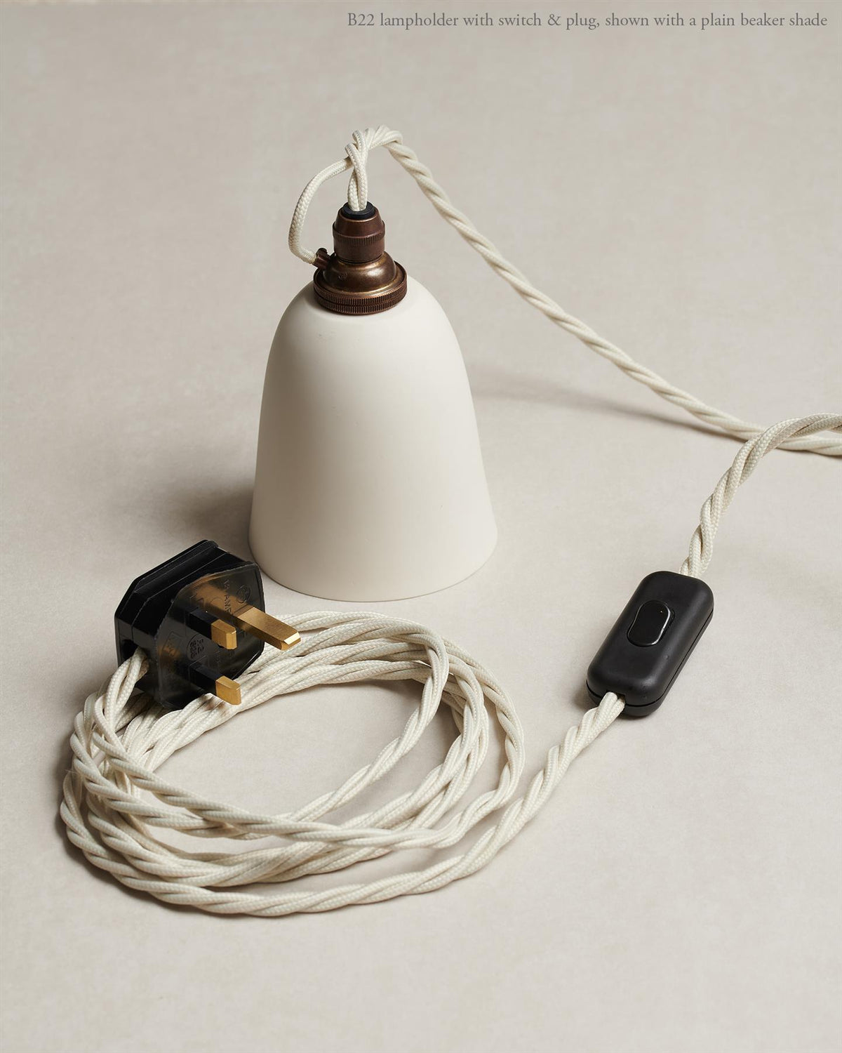 An oblique view of a small pleated porcelain light hanging over a Carrara marble sink. TEST